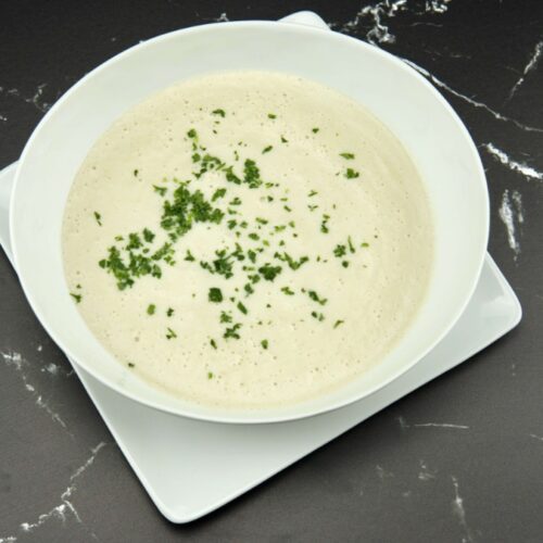 Bowl of creamy sunchoke soup (Jerusalem artichoke soup) garnished with chives