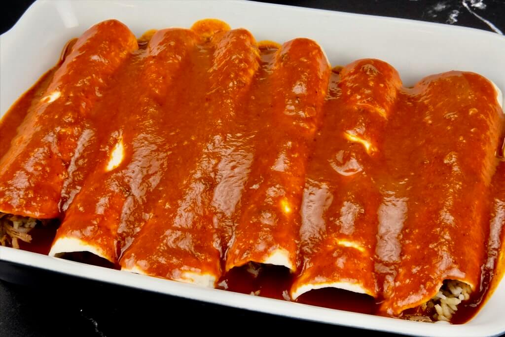 rolled birria enchiladas with sauce ready for baking