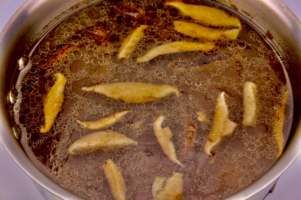 sauteed mushroom boiling in a pot of stock for homemade ramen recipe