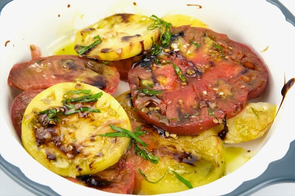 a serving of marinated tomatoes with burrata