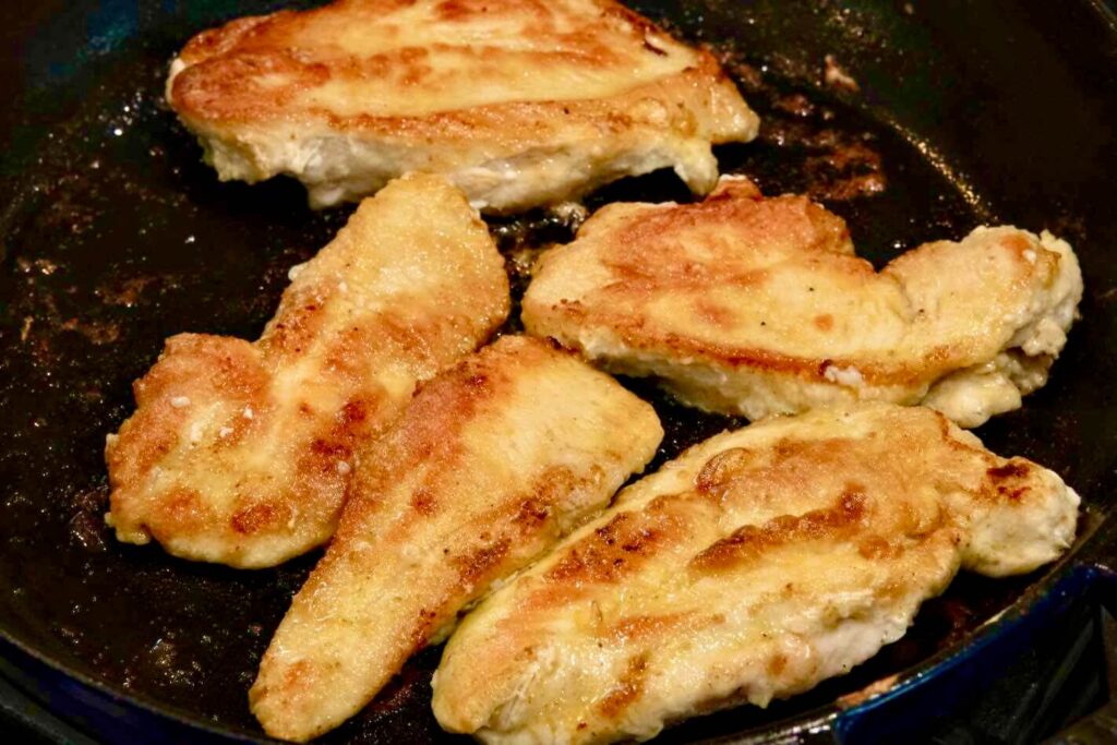 browning the chicken on a pan with olive oil and butter