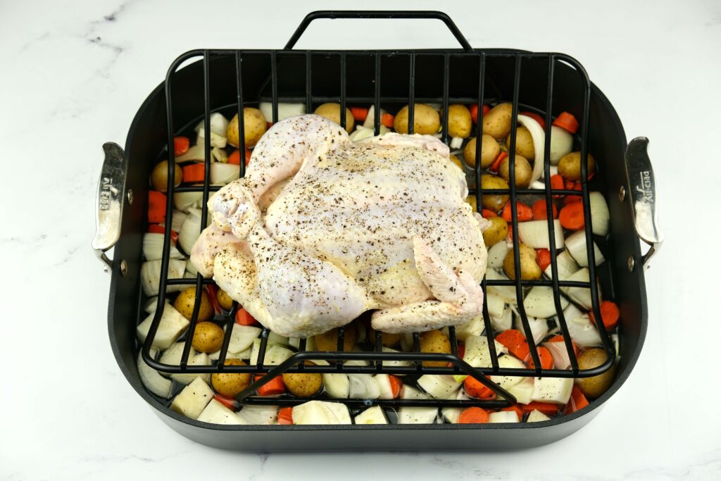 buttermilk-brined chicken on top of vegetables, ready for roasting