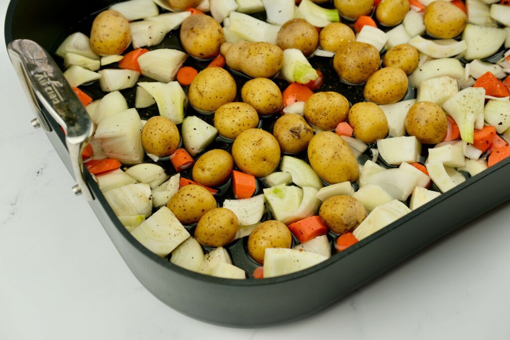 roasting pan with root vegetables for the Buttermilk-Brined Roast Chicken