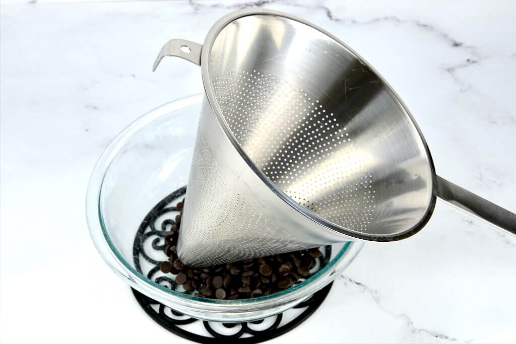 chocolate chips in a bowl with a sieve