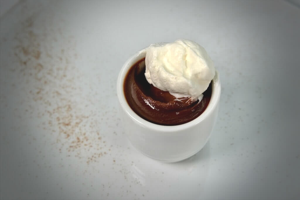 a serving of spiced chocolate budino with whipped cream