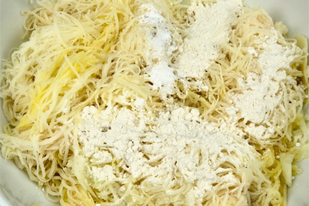 flour, baking powder, salt, and pepper added to shredded potatoes and onions