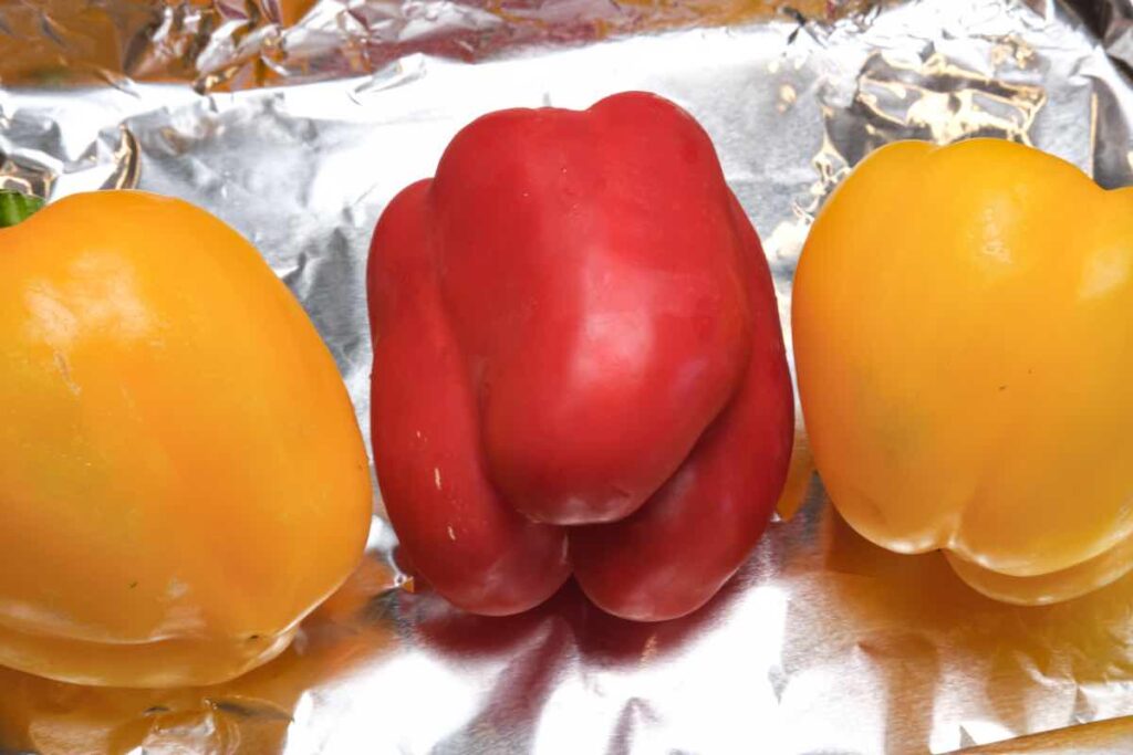 red and yellow peppers being prepped for roasting